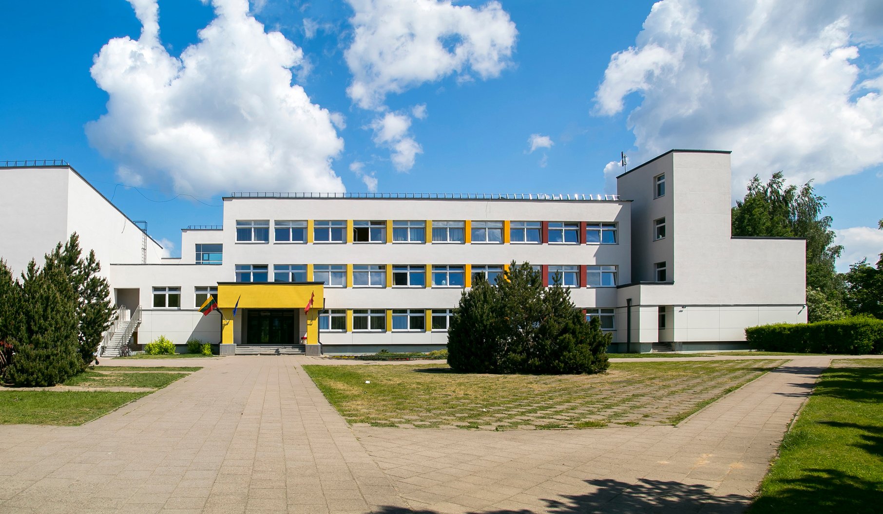 Public school building. Exterior view of school building with playground